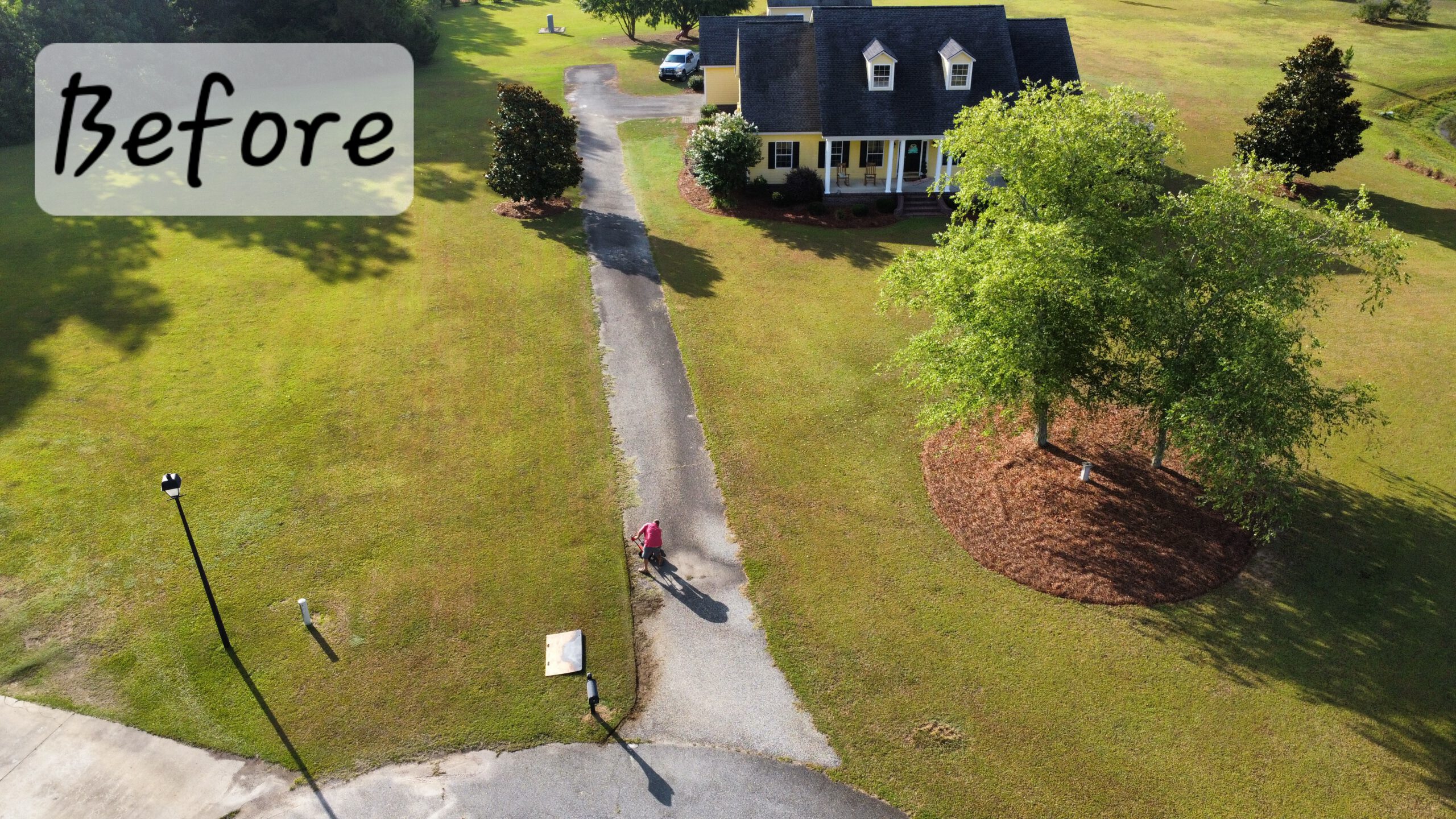Worn light driveway with dirt patches before sealcoating