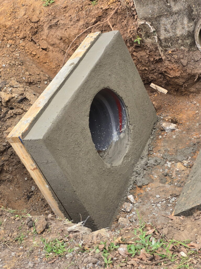 Cast in place concrete endwall poured around a drainage pipe