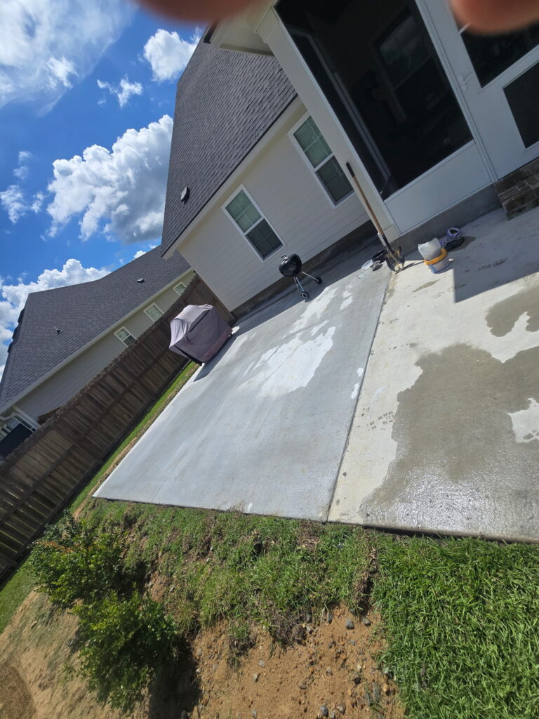 Finished concrete patio slab poured behind a home